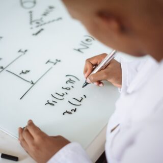 photo of person deriving formula on white board