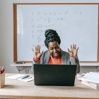happy black woman using laptop for online work
